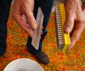 Slap ski wax brush against a wax scraper