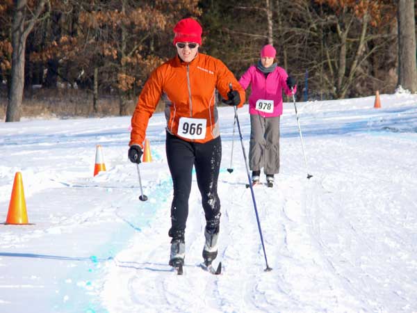Ron Baker (Orange) and Denise Daberko striding on the course. This was Daberko's first ever cross country ski race