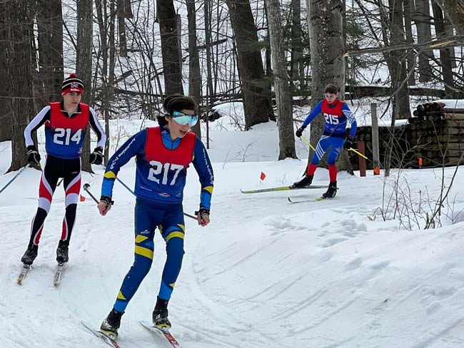Three male cross countries skier rounding a fast downhill corner