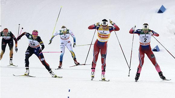 Marit Bjoergen leads out a sprint to the finish as Kikkan Randall (left) gets on the podium for the first time since winning in Lahti a year ago. (Getty Images/AFP-Martti Kainulainen)