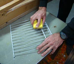 Scrape brush across wire shelf