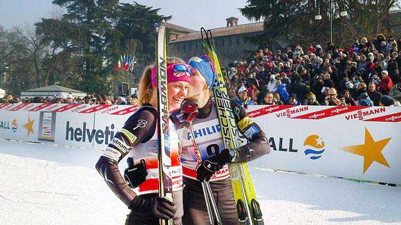 essie Diggins gets a congratulatory hug and kiss from teammate Kikkan Randall after their second place finish in the Milan World Cup team sprint. (USSA-Matt Whitcomb)