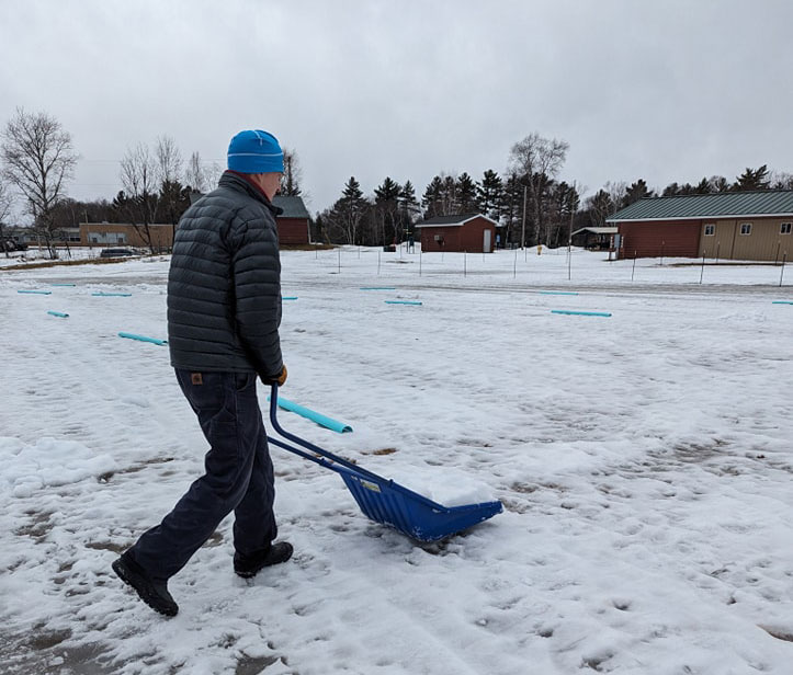 Shoveling snow onto the course